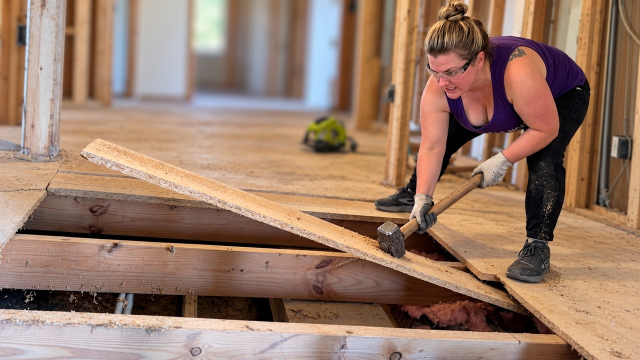 Bree breaking up the old trailer floor with a sledgehammer